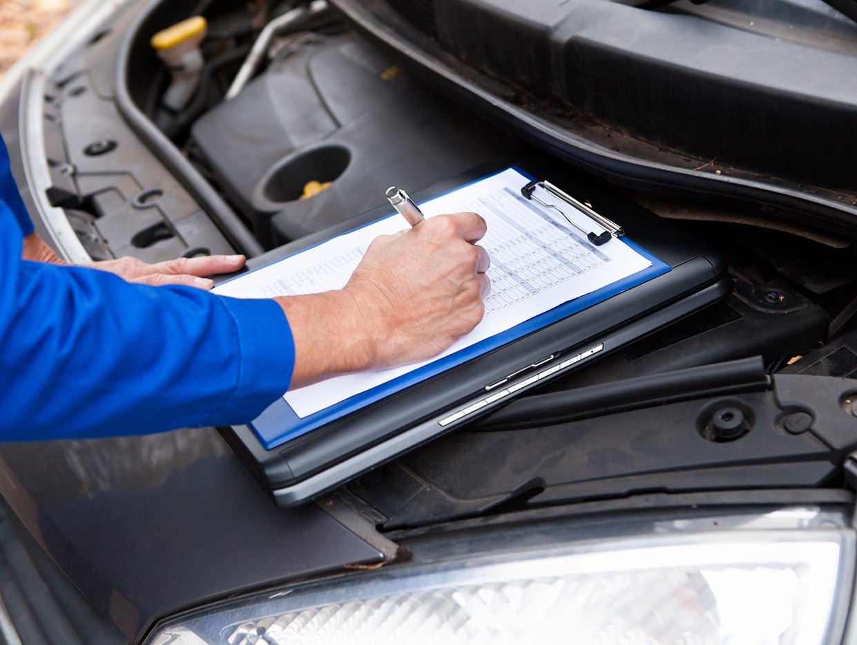 Service technician documenting a vehicle inspection